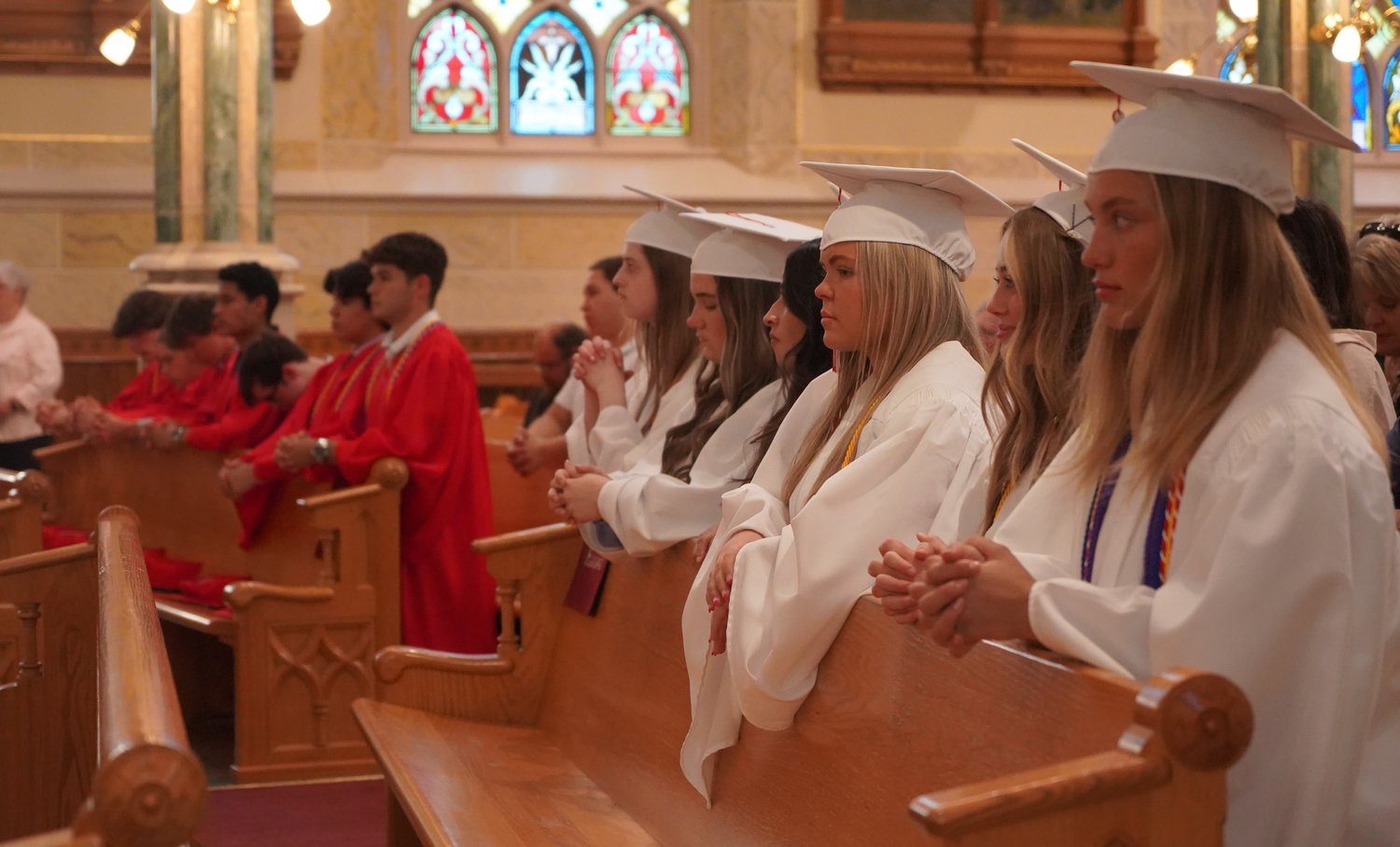Soon-to-be-graduating seniors of Sacred Heart High School in Sedalia kneel during their Baccalaureate Mass in Sacred Heart Chapel.